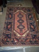 A Turkish rug in brown and pink shades, 74" x 47".