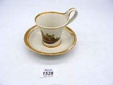 An early 19th century Empire style Furstenberg cup and saucer, the cup painted with landscapes,