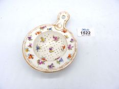 A scarce Dresden porcelain strainer, painted with flowers, c. 1900, 5 3/8'' including handle.
