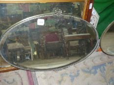 An oval bevelled Wall Mirror with bow detail, 27'' wide.