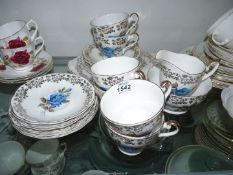 A bone china Teaset for six with blue rose and gilt pattern, no teapot.