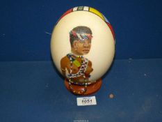 An Ostrich Egg painted with a picture of an African Lady with beads.