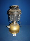 A vintage gold coloured Tilley lamp.