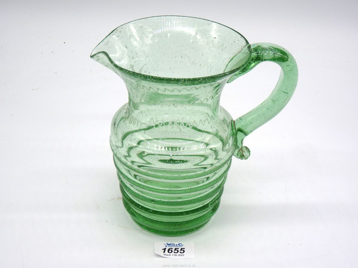 A hand blown green glass jug,