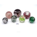 Seven paperweights including apples, Isle of Wight, Langham etc.