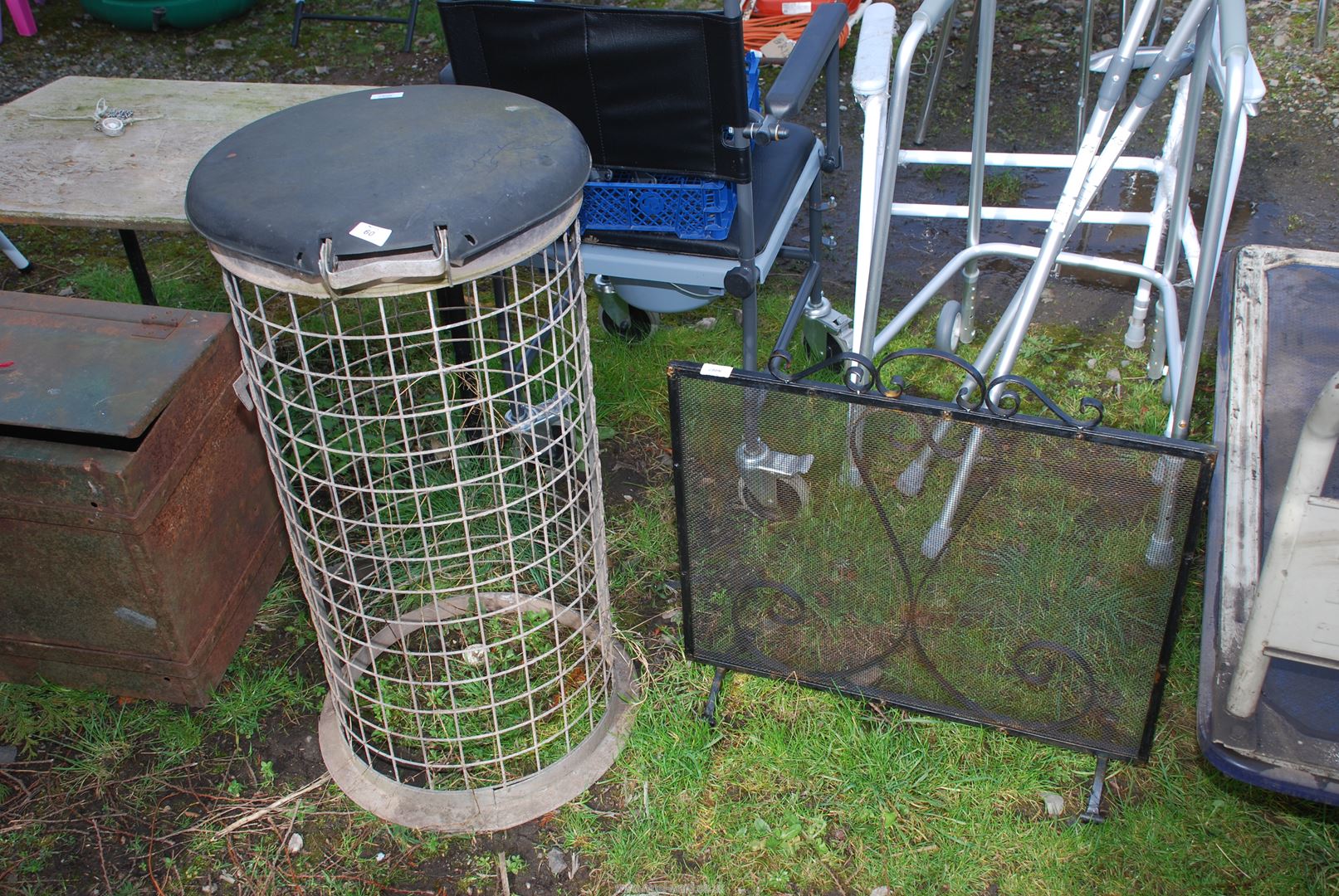 Wrought iron spark guard and galvanised mesh waste paper bin.