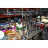 Twelve tall chrome 5 branch candle holders, 35" tall.