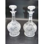 A pair of cut glass decanters with stoppers.