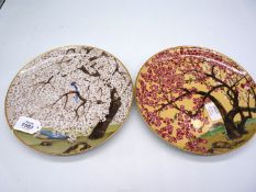 A pair of hand painted oriental plates of cherry blossom trees and birds