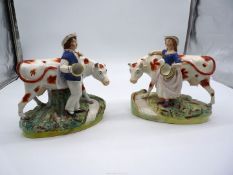 A pair of mid 19th c large Staffordshire figures of a Milkman and a Milkmaid with red and white