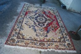 A red and cream patterned rug, 75" x 110", well worn.