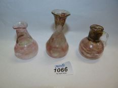 A set of three miniature Roman style glass flasks.