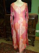 A vintage pink evening dress with long flowing sleeves, size 12 by Troubadour, sleeve damaged.
