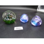 Three Caithness paperweights,one marked 'Myriad' and two small purple pebble shape.