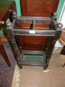 A dark wood two compartment Umbrella stand with a metal drip tray and turned legs, 28 1/2" tall.