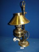 A brass electric lamp converted by Christopher Wray, with oil reservoir and ''coolie'' shape shade.