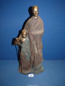A large and heavy Massai figure of a father & son, signed 'M', 20'' tall, (repair to boy's arm).