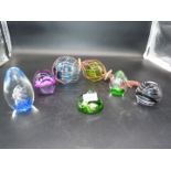 A quantity of glass paperweights including purple, floral, spiral, etc.