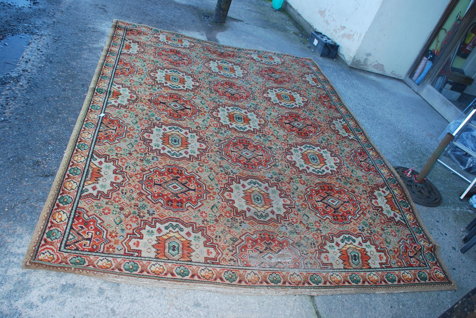 An orange and green rug, some worn areas, 122" x 90".