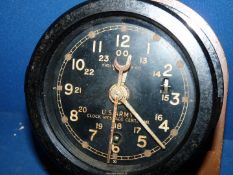 A cased bulkhead mounting clock having a clockwork movement.