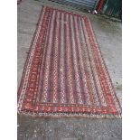 A vintage striped bordered, patterned and fringed Turkish rug, repaired, 10'6" x 4'10".