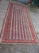 A vintage striped bordered, patterned and fringed Turkish rug, repaired, 10'6" x 4'10".