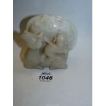 A small white hardstone carving with a figure of monkey on horse to one side and two fish swimming