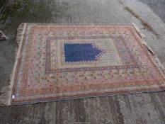 A bordered, patterned and fringed rug having geometric blue shield to centre, 6' 8 1/2" x 4' 10".