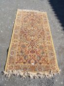 A Border and fringed gold patterned rug 73'' x 36''.