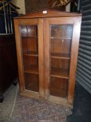 A Satinwood 19th century double door bookcase having a triangular pediment,