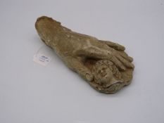 An unusual pottery Sculpture of a hand holding a head. 11" long.