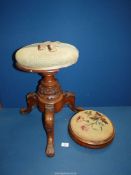 A Victorian revolving Piano stool with green upholstery standing on three carved legs,