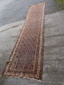 A multi-coloured border, patterned and fringed runner, 14' 3" x 3' 5", (very well worn).