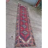 A vintage Turkish runner in reds and blues 'Doemeatli', 9' 6" x 2' 5".