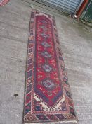 A vintage Turkish runner in reds and blues 'Doemeatli', 9' 6" x 2' 5".