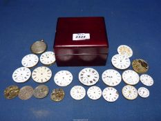 A square cigarette box containing 19 pocket watch movements for spares/repairs and three watch