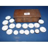 A wooden cigarette box containing 16 pocket watch movements for spares/repairs and a loose watch