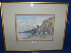 A framed and mounted Watercolour of a coastal scene with a figure on the beach and rugged cliffs,