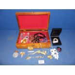 A wooden jewelry box containing assorted jewellery, necklaces,a lizard brooch, pendants,