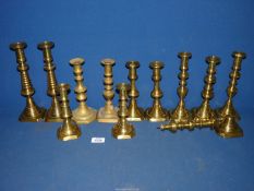 A quantity of brass candlesticks including four pairs, etc. some with pushers.