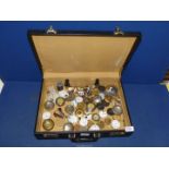 A briefcase containing a large quantity of watch parts, pendulum bob-weights, watch cases etc.