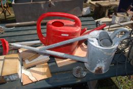 A galvanised watering can (a/f) and a red plastic watering can.