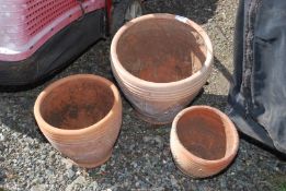 A set of three terracotta pots.