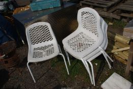 Four plastic stackable chairs.