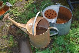 A galvanised watering can with rose and a mop bucket.