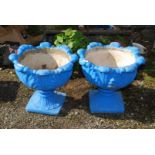 Two concrete planters painted blue, 17'' high x 19'' wide.