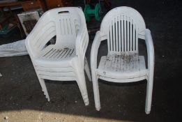 Six white stackable chairs.