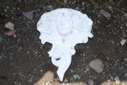 A garden wall pocket in the shape of a female head.