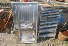A stainless steel 1 1/2 bowl sink top and a chrome towel radiator.