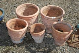 A set of five terracotta pots.